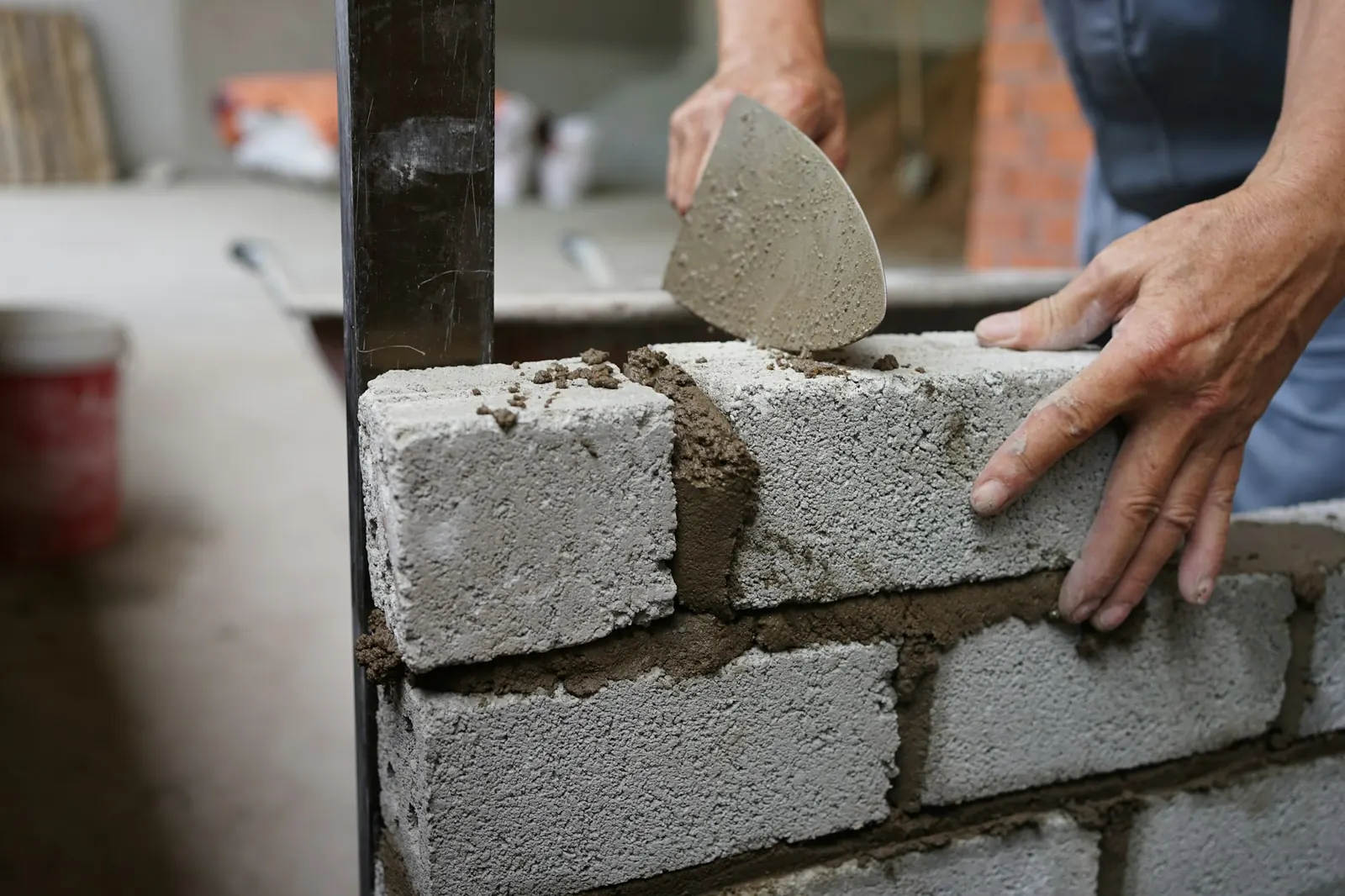 Muratore che posa blocchi con la cazzuola