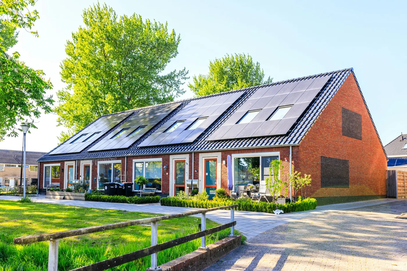 Casa con tetto fotovoltaico e prato verde
